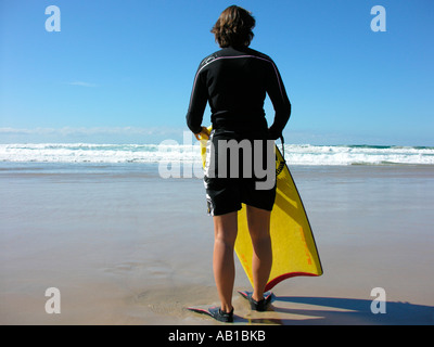 Junge Frau am Strand mit Boogie-board Stockfoto