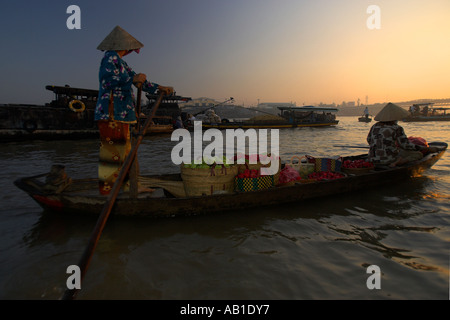 Frau in konische Hut Zeilen Flussschiff mit Mangos und Wachs Äpfel bei Sonnenaufgang Cai Ran schwimmenden Markt in der Nähe können Tho Vietnam Stockfoto