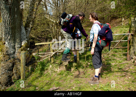 Wanderer durchqueren Stile auf Fußweg in den schwarzen Bergen im Tal des Ewyas in der Nähe von Llanthony Priory Monmouthshire South Wales UK Stockfoto