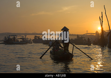 Frau in konische Hut Zeilen Flussschiff mit Obst bei Sonnenaufgang Cai Ran schwimmenden Markt in der Nähe können Tho Vietnam Stockfoto