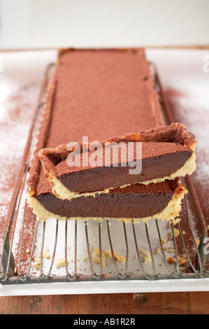 Rechteckige Schokolade Torte mit Kakao-Pulver schneiden Sie ein Stück FoodCollection Stockfoto