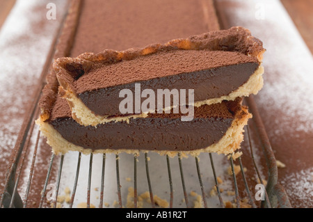 Rechteckige Schokolade Torte mit Kakaopulver in Scheiben teilweise FoodCollection Stockfoto