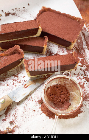 Rechteckige Schokolade Torte mit Kakaopulver in Scheiben teilweise FoodCollection Stockfoto