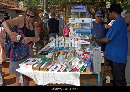 Frau Besucher Packungen Zigaretten in der Tasche auf billige Zigaretten stall Anjuna Flohmarkt Goa Indien Stockfoto