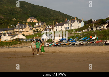 Gruppe von 3 Personen zu Fuß am Strand von Tresaith Cardigan Bay Ceredigion West Wales Sommerabend Stockfoto