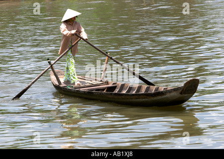 Frau in konische Hut Paddlling Fähre über den Fluss Mekong Delta Vietnam Stockfoto