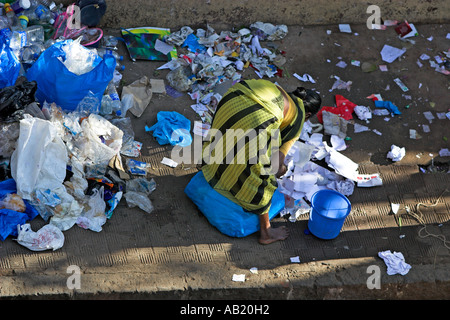 Barfuß Frau im Sari nimmt über Straße Müll am frühen Morgen Mumbai Indien Stockfoto