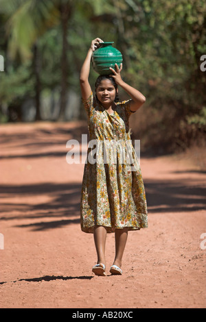 Junge Mädchen trägt grüne Wassertopf auf Kopf Mandrem Dorf Goa Stockfoto