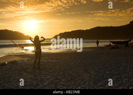 Badeanzug Mädchen drehte Poi Bänder im Sonnenuntergang Palolem Beach Süd Goa-Indien Stockfoto