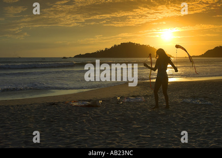 Badeanzug Mädchen drehte Poi Bänder im Sonnenuntergang Palolem Beach Süd Goa-Indien Stockfoto