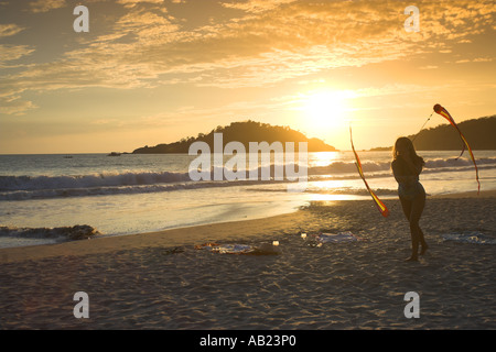 Badeanzug Mädchen drehte Poi Bänder im Sonnenuntergang Palolem Beach Süd Goa-Indien Stockfoto