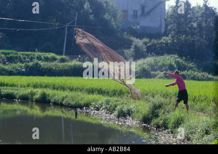 Mann wirft ein Netz in einen Teich Xiangtan Hunan China Stockfoto