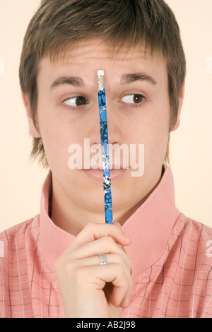 Junger Mann mit Bleistift auf der Stirn Stockfoto