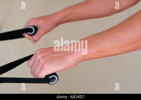 Detail der Hände halten Griffe am Heimtrainer Stockfoto