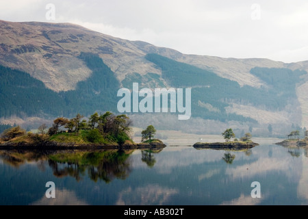 Bäume auf den Inseln spiegelt sich in den stillen Wassern des Loch Leven Ballachulish Glencoe The Highlands Schottland Stockfoto