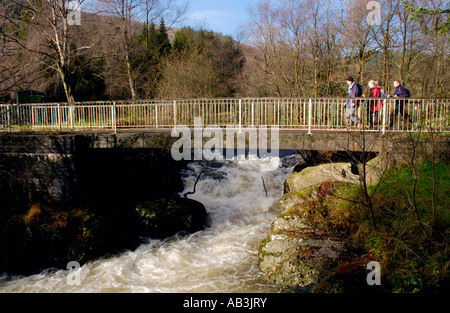 Wanderer, die Teilnahme an Real Ale Wanderung walking Festival überqueren die schnell Irfon der Flowimg River in der Nähe von Llanwrtyd Wells Powys Mid Wales Stockfoto