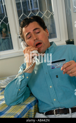 Mann am Telefon mit Kreditkarte Stockfoto