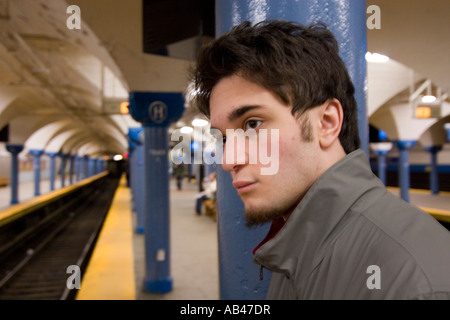 Ein junger Mann wartet eine u-Bahn in einer u-Bahnstation Stockfoto