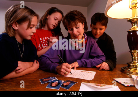 Frau in Vereinigten Staaten schreibt einen Brief mit ihren 3 Kindern auf Stockfoto