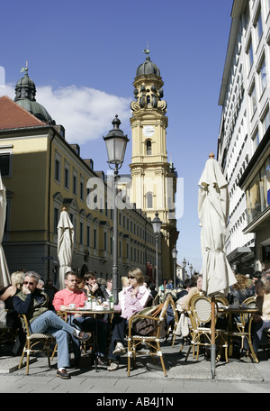 Menschen sitzen in einem Straßencafé in Theatiner Straße, München, Deutschland. Stockfoto
