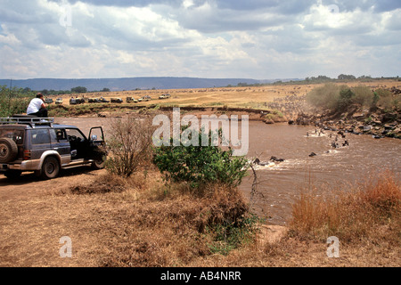 Touristen in einem 4 X 4 Ansicht von Zebras und Gnus, die Überquerung des Mara Flusses während der jährlichen Migration in Kenia. Stockfoto