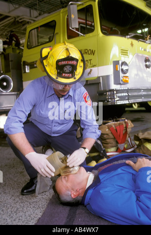 Feuerwehrmann kümmert sich um ein Opfer in einer Notfall-Situation nach einem Autounfall Stockfoto