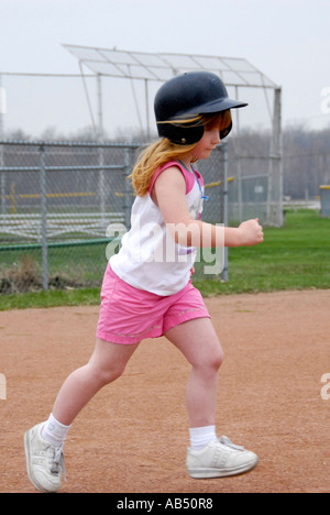 5 Jahre alten ausgeführt, trägt einen Schutzhelm und Tennisschuhe Stockfoto