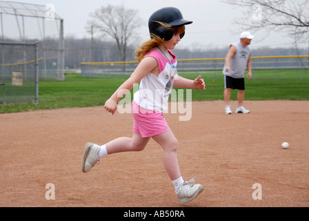 5 Jahre alten ausgeführt, trägt einen Schutzhelm und Tennisschuhe Stockfoto