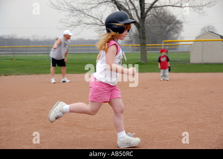 5 Jahre alten ausgeführt, trägt einen Schutzhelm und Tennisschuhe Stockfoto