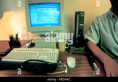 Ärzte-Schreibtisch in Allgemeinmedizin Familienmedizin mit Patienten Blutdruckmessgerät Auriscope Instrumente und Computer-terminal Stockfoto