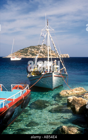 Fischer ausbessern Netze in einem Fischerboot vor Anker bei Agios Nikolaos im Nordosten der griechischen Insel Zakynthos, Griechenland Stockfoto