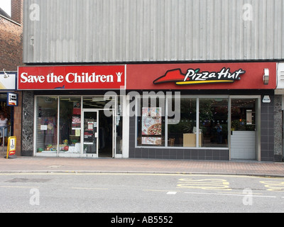 High Street Brentwood Essex speichern die Kinder Charity-Shop befindet sich neben einem Schnellrestaurant Pizza Hut Stockfoto