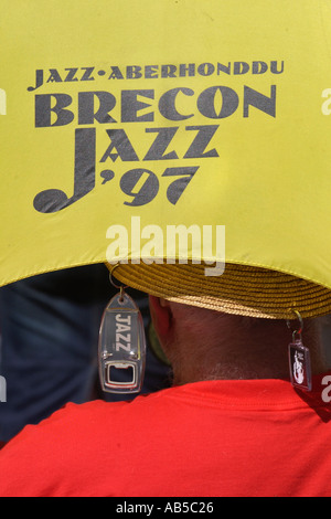 Jazzfan mit einem Regenschirm als Sonnenschutz an der jährlichen Brecon Jazz Festival Powys Mid Wales UK Stockfoto