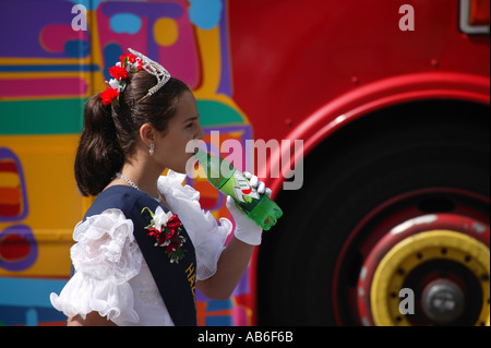 Karnevalskönigin trinken eine Cola zu Fuß neben einem alten bus Stockfoto