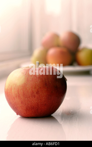 ÄPFEL AUF FENSTERBANK MIT EINEM APFEL IM VORDERGRUND 70ER STYLE FARB-BALANCE Stockfoto