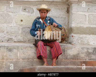 Älteren Einheimischen Mann in traditionellen Maya dress spielen Trommel vor der Kathedrale von Panajachel, Gutemala Stockfoto