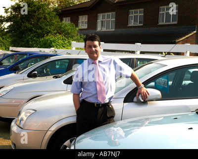 Gebrauchte Auto-Verkäufer unter den Autos Stockfoto