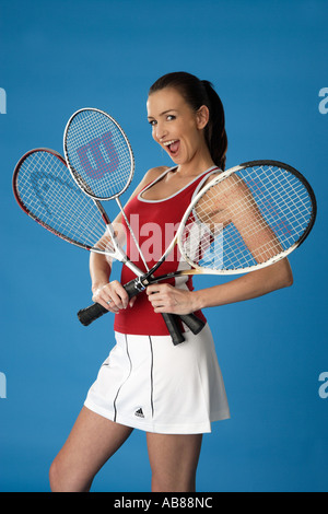 Porträt einer Joung Darkhaired Frau im Sport-Outfit mit Squash, Badminton und Tennis Schläger Stockfoto