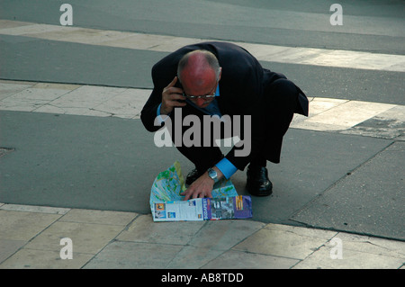 Mann mit Handy und Prüfung einer Reiseführer-Karte in Budapest Ungarn Stockfoto