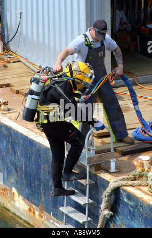 Taucher, die ins Wasser im Hafen von Torquay, zur Durchführung von Wartungsarbeiten am Steg Stockfoto