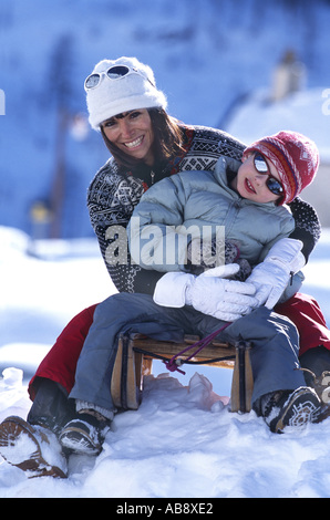 junge Frau mit Kind auf Schlitten. Stockfoto