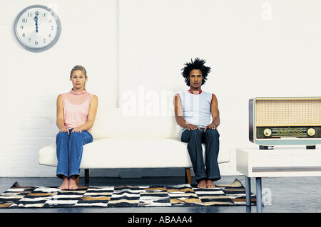 Paar, sitzen an den entgegengesetzten Enden des Sofas Stockfoto