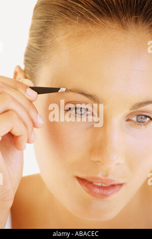 Frau zupfen Augenbrauen Stockfoto