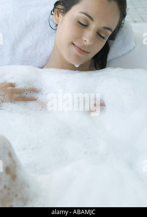 Frau liegend im Schaumbad Stockfoto