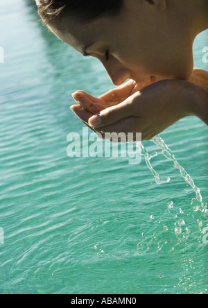 Frau beugte sich über Wasser, Schröpfen Wasser stellen Stockfoto