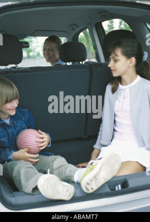 Kinder sitzen im Kofferraum eines Autos Stockfoto