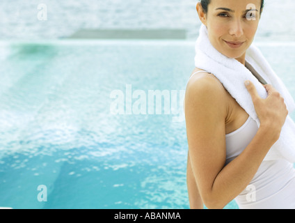Frau mit Handtuch um den Hals, Pool im Hintergrund Stockfoto