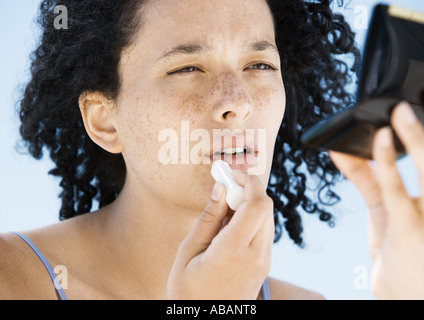Frau Anwendung Lippenbalsam, mit kompakten Stockfoto