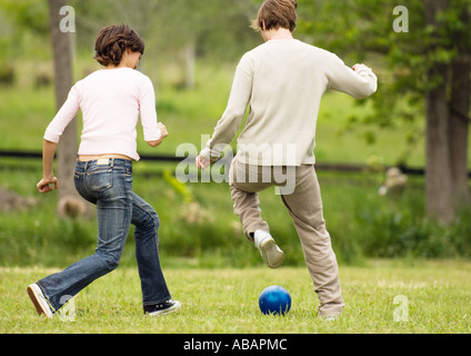 Zwei Freunde Ball nachlaufen Stockfoto