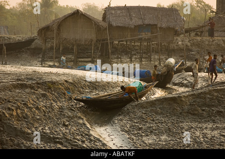 Fischer, schieben ihre Boote zum Fluss bei Ebbe im Morgennebel, Shibsha Fluss, Bangladesch. Stockfoto